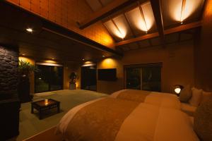 a large bedroom with a large bed and a tv at Hakone Kairai in Hakone