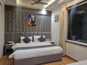a bedroom with a large bed and a window at Platinum Arc in Jaipur +10 photos
