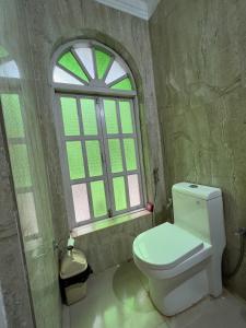 a bathroom with a toilet and a window at Villa Rivercat in Mandrem