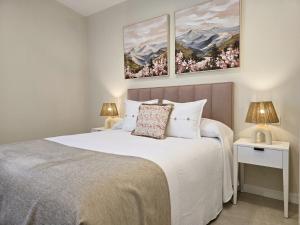 a bedroom with a large white bed with two lamps at LURDE Apartamentos Rurales in El Cerezal +107 photos