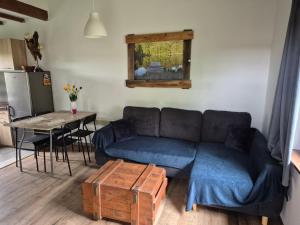 a living room with a blue couch and a table at Chatki u Patki in Łebieniec