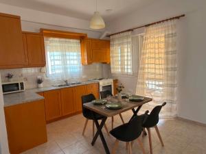 a kitchen with a table and chairs in a kitchen at Thea in Myrtos