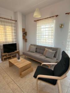 a living room with a couch and a tv at Thea in Myrtos