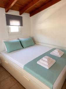 a bed in a room with two towels on it at Thea in Myrtos