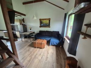 a living room with a blue couch and a table at Chatki u Patki in Łebieniec +23 photos