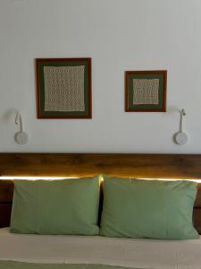 two lights above a bed with two green pillows at Olive Haven in Provatas