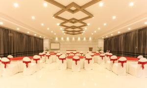 a banquet hall with tables and chairs in a room at Hotel Sunrise Luxury Stays in Chikmagalūr