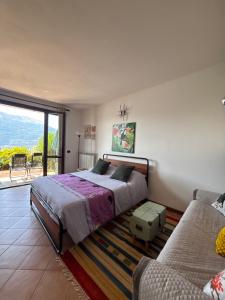 a bedroom with a bed and a couch at residenza gelsomino - relax and view in Bellano