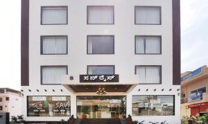 a white building with a sign on it at Hotel Sunrise Luxury Stays in Chikmagalūr