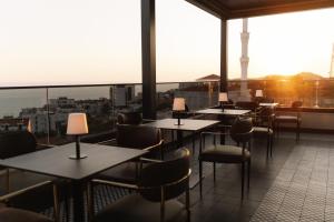 ein Restaurant mit Tischen und Stühlen auf einem Balkon in der Unterkunft Hotel Dolcinium in Ulcinj