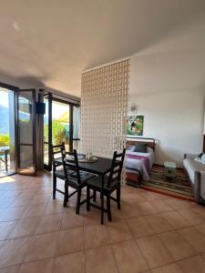 a living room with a table and chairs and a bed at residenza gelsomino - relax and view in Bellano