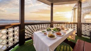 a table with food on a balcony with a view of the ocean at Taean Tteulapbada Pension in Taean
