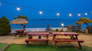 a picnic table and benches with a view of the ocean at Taean Tteulapbada Pension in Taean