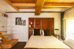 a bedroom with a large bed and wooden ceilings at La petite maison CARRÉ in Talant