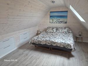 a bedroom with a bed in a attic at Ferielejlighed Solbakke in Østermarie