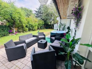 a patio with couches and a table and chairs at Juicy Private Apartments with Jacuzzi in Szentendre