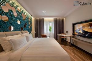 a hotel room with a large bed and a flat screen tv at Cubicity Hoang Dieu in Ho Chi Minh City
