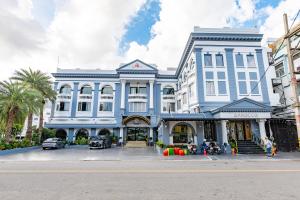 a large blue and white building on a street at Kiss Gardenhome Chic Hotel in Hat Yai