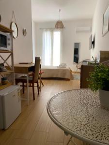 a living room with a table and a bedroom at Casa Mamà in Marzamemi +18 photos