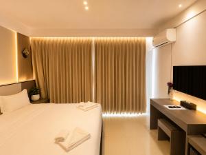 a hotel room with a bed and a television at Happy Room 3 in Pattaya South