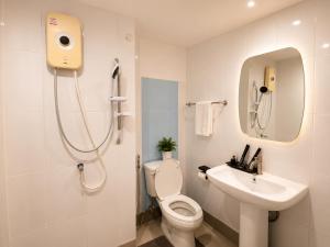 a white bathroom with a toilet and a sink at Happy Room 3 in Pattaya South