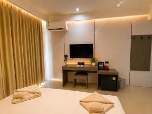 a bedroom with a desk and a tv on the wall at Happy Room 3 in Pattaya South