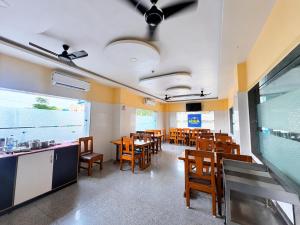 a dining room with wooden tables and chairs at Hotel The Four Square in Digha