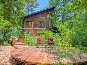 a cabin in the woods with two chairs on a wooden deck at Akamatsu House in Hakuba
