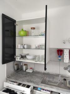 a kitchen with a sink and a shelf with dishes at Apartman Garami Porta in Mezőkövesd +29 photos