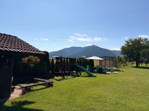 a yard with a playground with mountains in the background at Penzion Mlynárov Dvor in Dúbrava