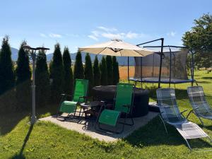 a table and chairs under an umbrella in a yard at Penzion Mlynárov Dvor in Dúbrava +44 photos