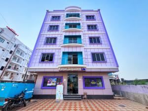 a tall white building with a foursquare sign on it at Hotel The Four Square in Digha