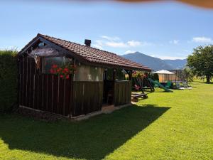 a small building with flowers in the window at Penzion Mlynárov Dvor in Dúbrava