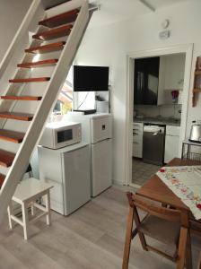 a living room with a staircase and a kitchen at Apartman Garami Porta in Mezőkövesd