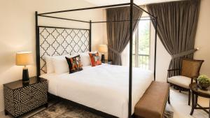 a bedroom with a large white bed and a chair at SkyHouse by Ace Luxe in Islamabad +32 photos