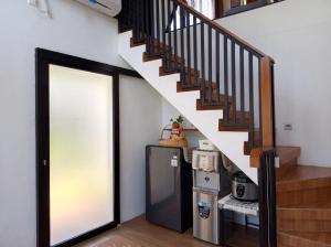 a staircase leading up to a kitchen with a refrigerator at Villa Kahuripan Triangle in Bandung +4 photos