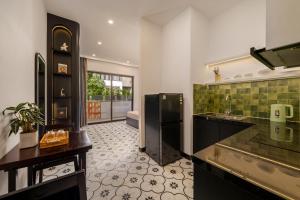 a kitchen with a black refrigerator and a sink at An Hiên Home in Danang