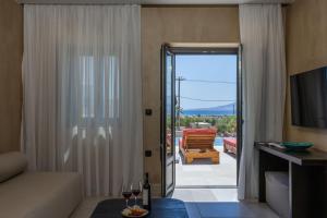 a living room with a sliding glass door to a patio at Melidron Hotel Suites Villas in Agios Prokopios