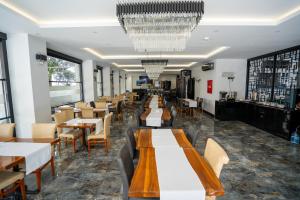 a restaurant with tables and chairs and a chandelier at Business Life Hotel & SPA Bakırköy in Istanbul