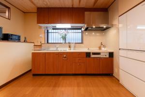 a large kitchen with wooden cabinets and a sink at Villa Taniguchi in Takayama