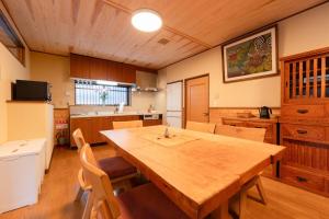 a large kitchen with a wooden table and chairs at Villa Taniguchi in Takayama