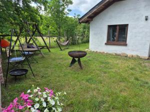 a yard with chairs and a table and a swing at Chatki u Patki in Łebieniec