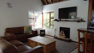 a living room with a couch and a fireplace at La Casita House in St Francis Bay