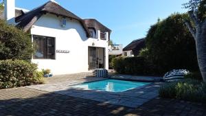 a swimming pool in front of a house at La Casita House in St Francis Bay