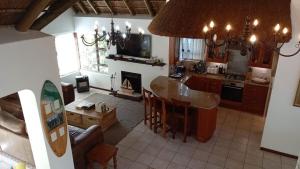 a kitchen and living room with a table and a fireplace at La Casita House in St Francis Bay