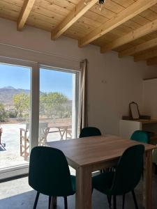 a dining room with a wooden table and green chairs at Olive Haven in Provatas
