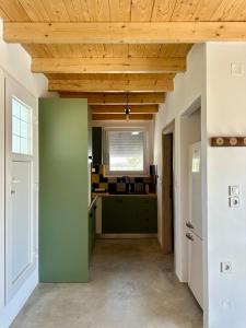 a kitchen with green cabinets and a wooden ceiling at Olive Haven in Provatas