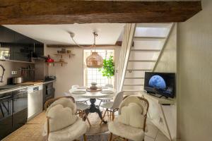 a kitchen with a table and chairs and a television at La petite maison CARRÉ in Talant