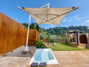 a large umbrella on top of a patio at Maple Dome Glamping in Bandung
