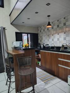 a kitchen with a counter and some chairs in it at Sítio Casa Verde in Uruguaiana +14 photos
